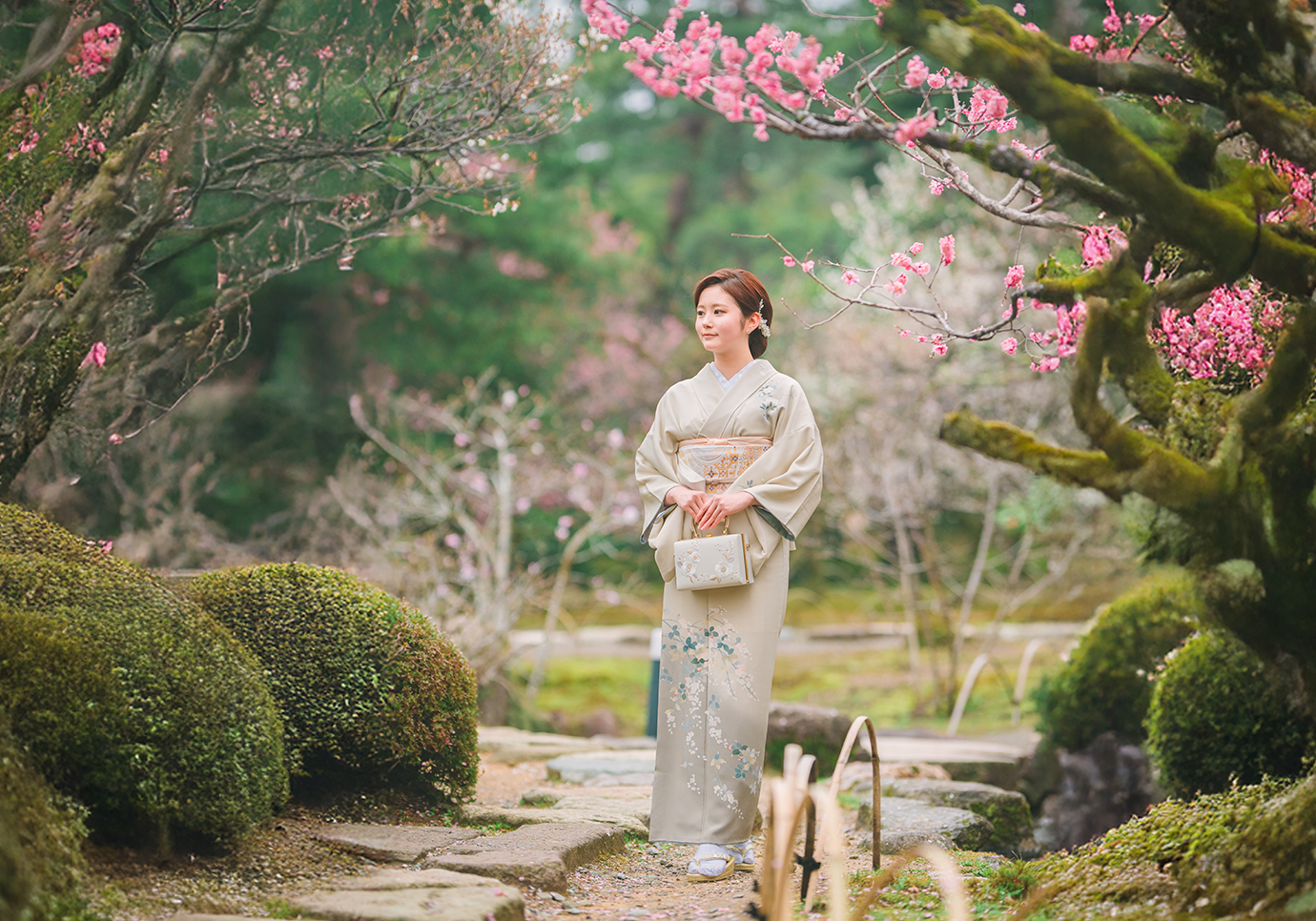 池のそばを散策している着物姿の女性