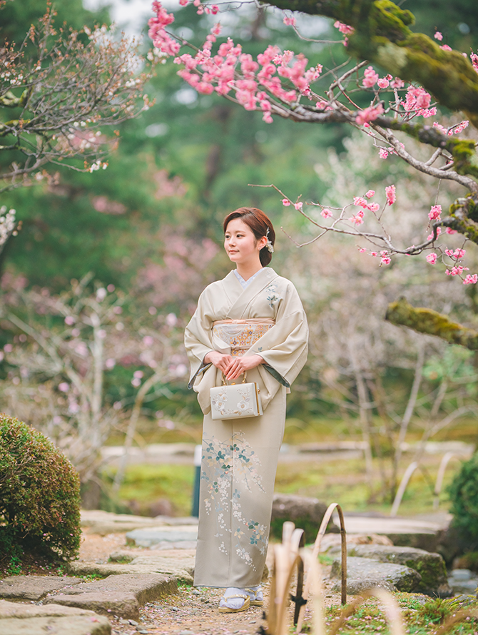 池のそばを散策している着物姿の女性